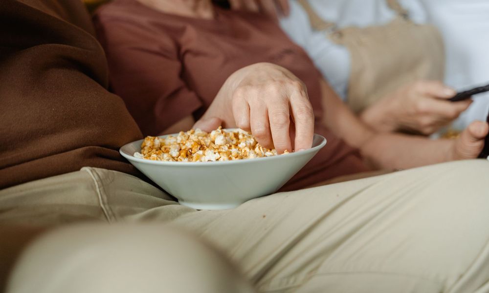 Couple partageant une soirée film avec du pop-corn
