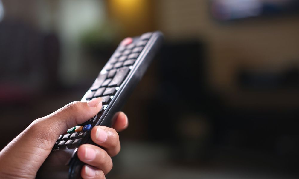 Télécommande de téléviseur en main