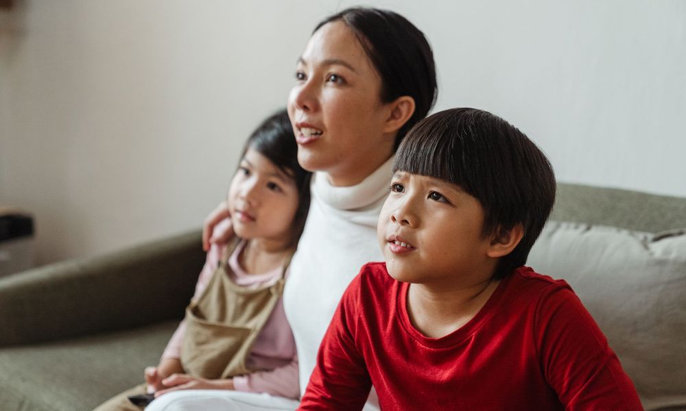 Une mère et ses enfants regardent la télévision