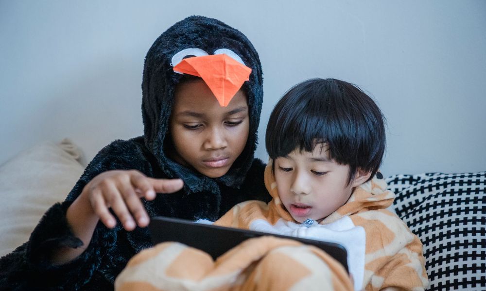 Deux enfants partagent une tablette pour regarder un programme