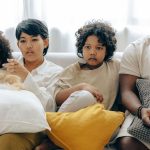 Famille réunie sur le canapé devant la télévision