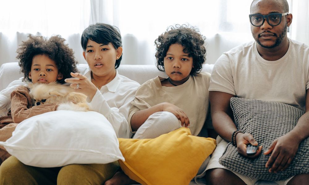 Famille réunie sur le canapé devant la télévision