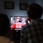 Spectateur regardant un match de football à la télévision