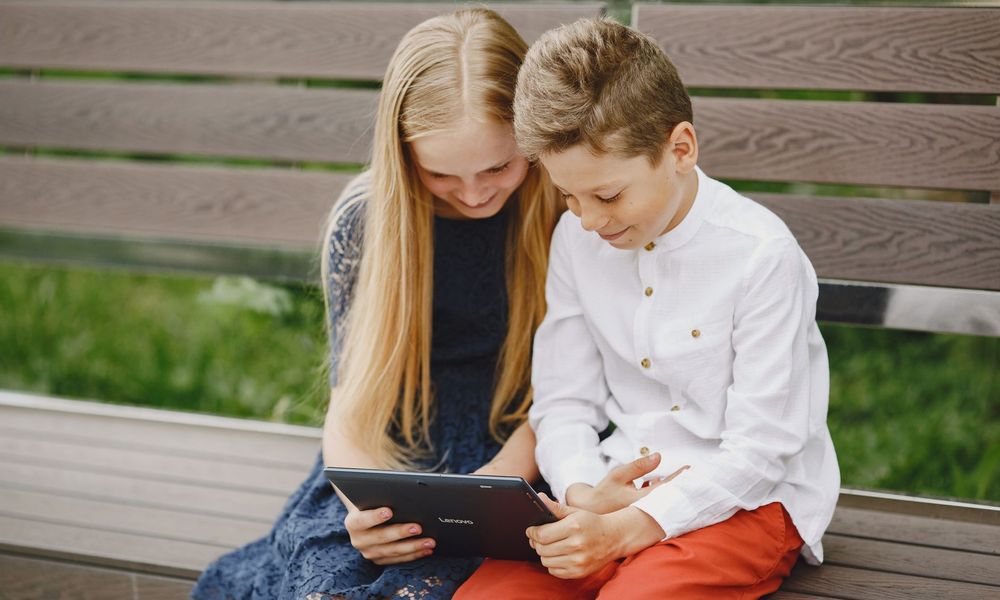 Enfants regardant une tablette en extérieur