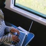Voyageur regardant un contenu sur son ordinateur portable en déplacement